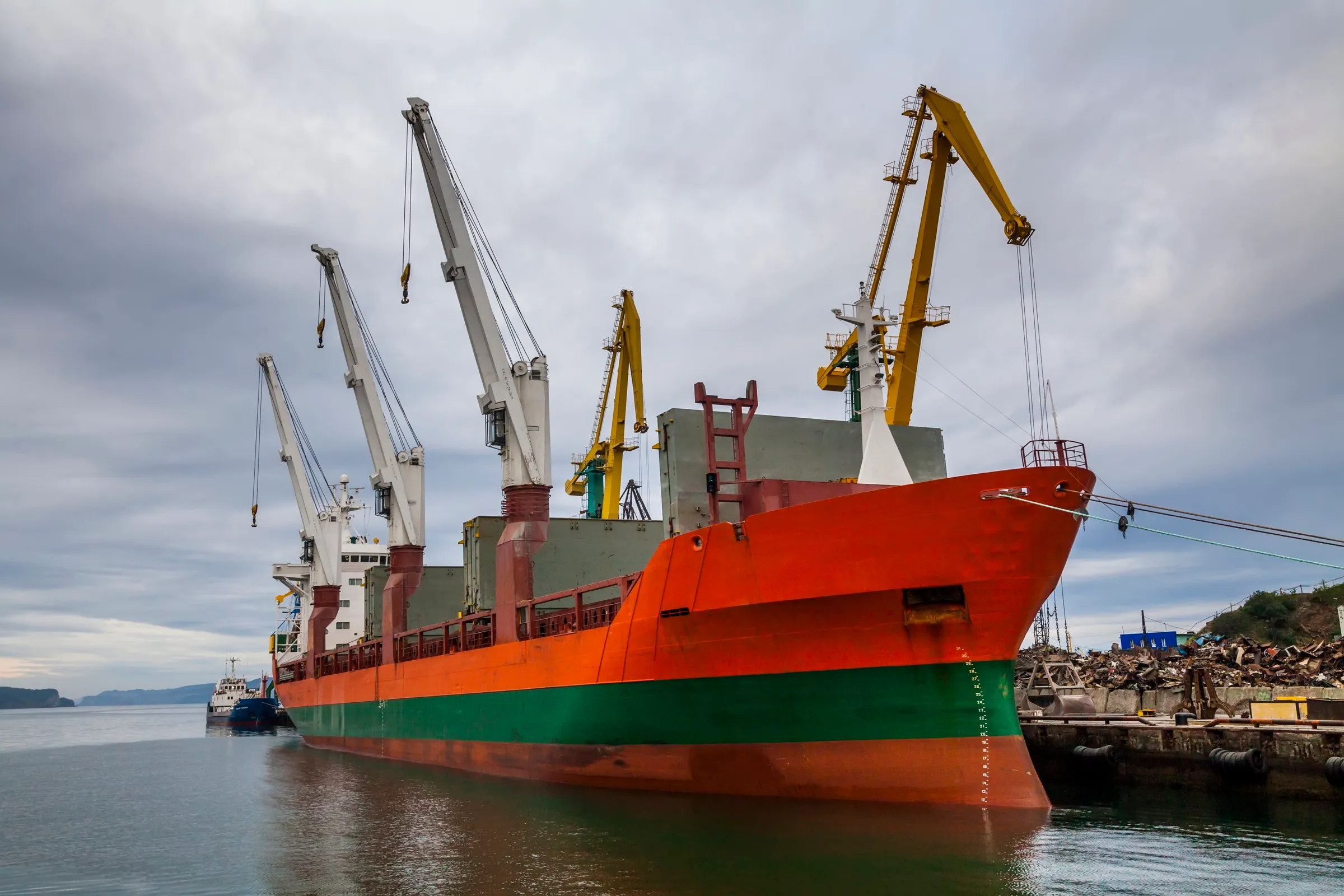 General cargo vessel alongside a berth with cranes