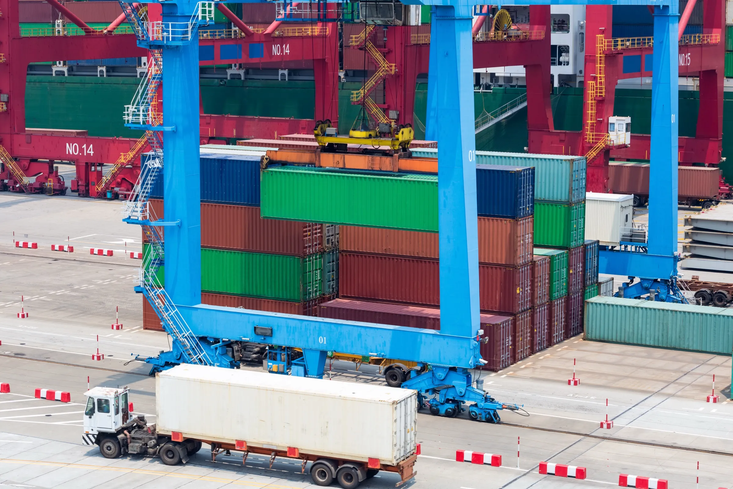 Yard crane lifting a container over a terminal stack during cargo operations