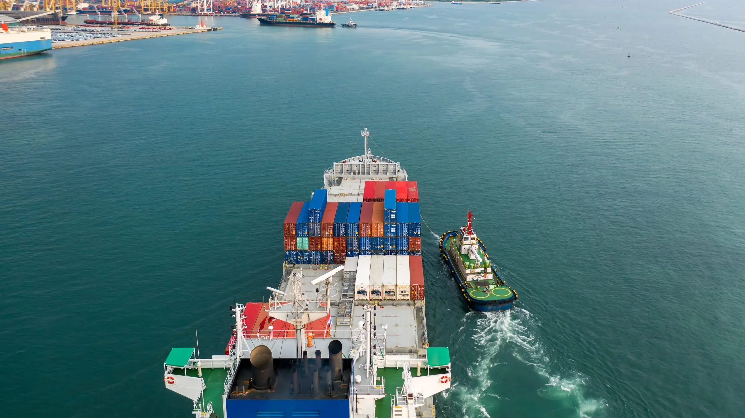 Tugboat assisting a container vessel on approach to port