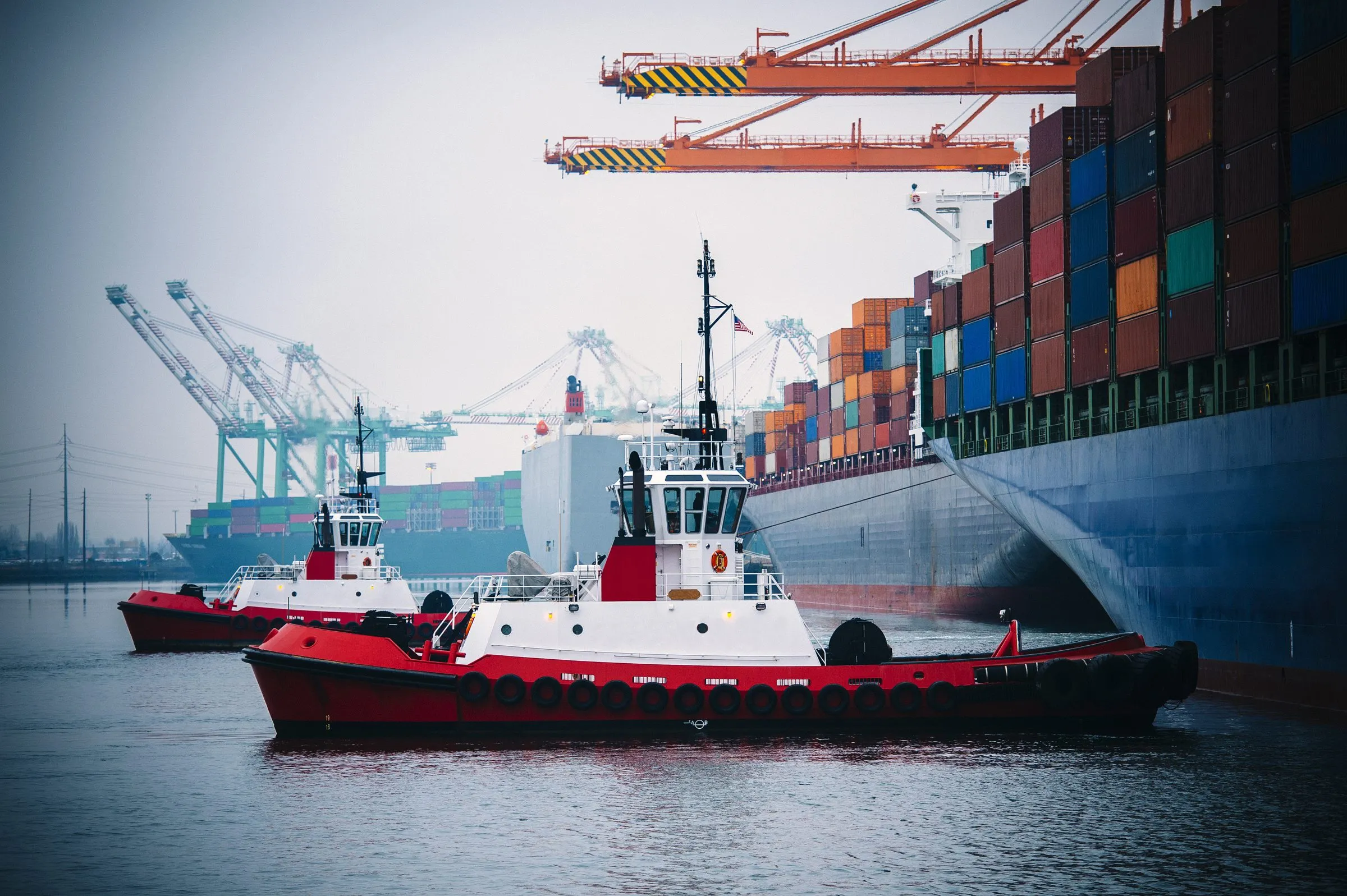 Tugboat alongside a container ship at berth